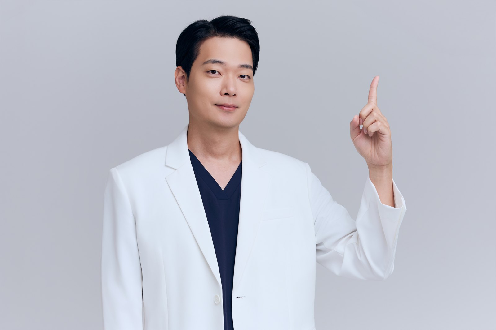 원장이 조명 아래에서 환자의 눈밑 상태를 진단하는 모습 (눈가 클로즈업, 비식별 처리)